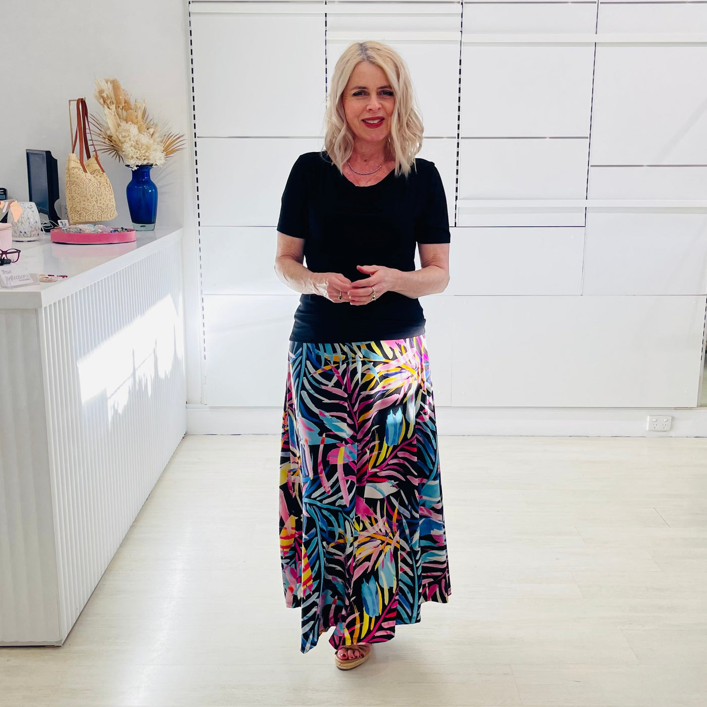 Woman wearing black dressy top with long floral maxi skirt. 