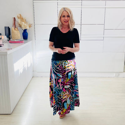 Woman wearing black dressy top with long floral maxi skirt. 