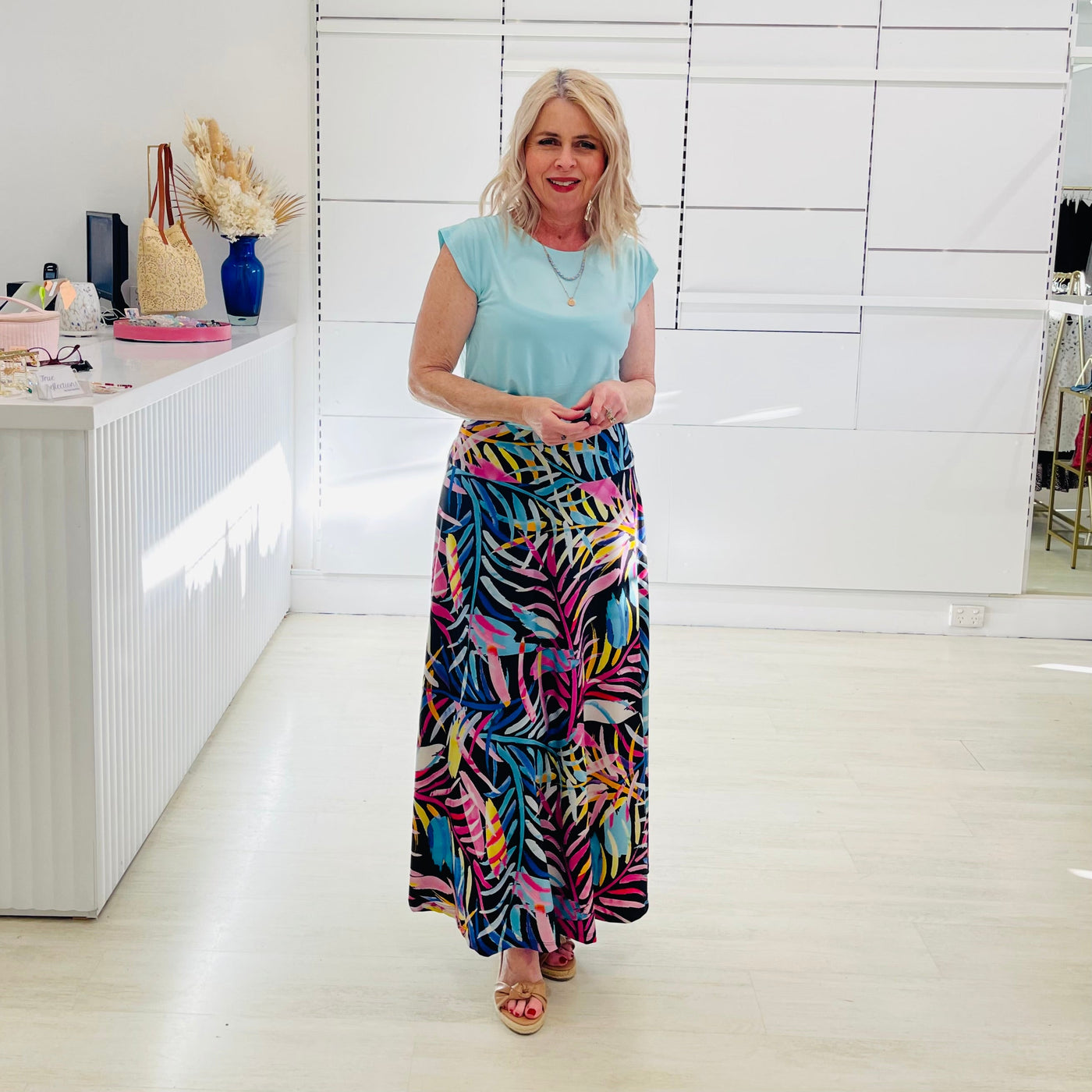 Woman wearing green  t shirt with long floral skirt. 