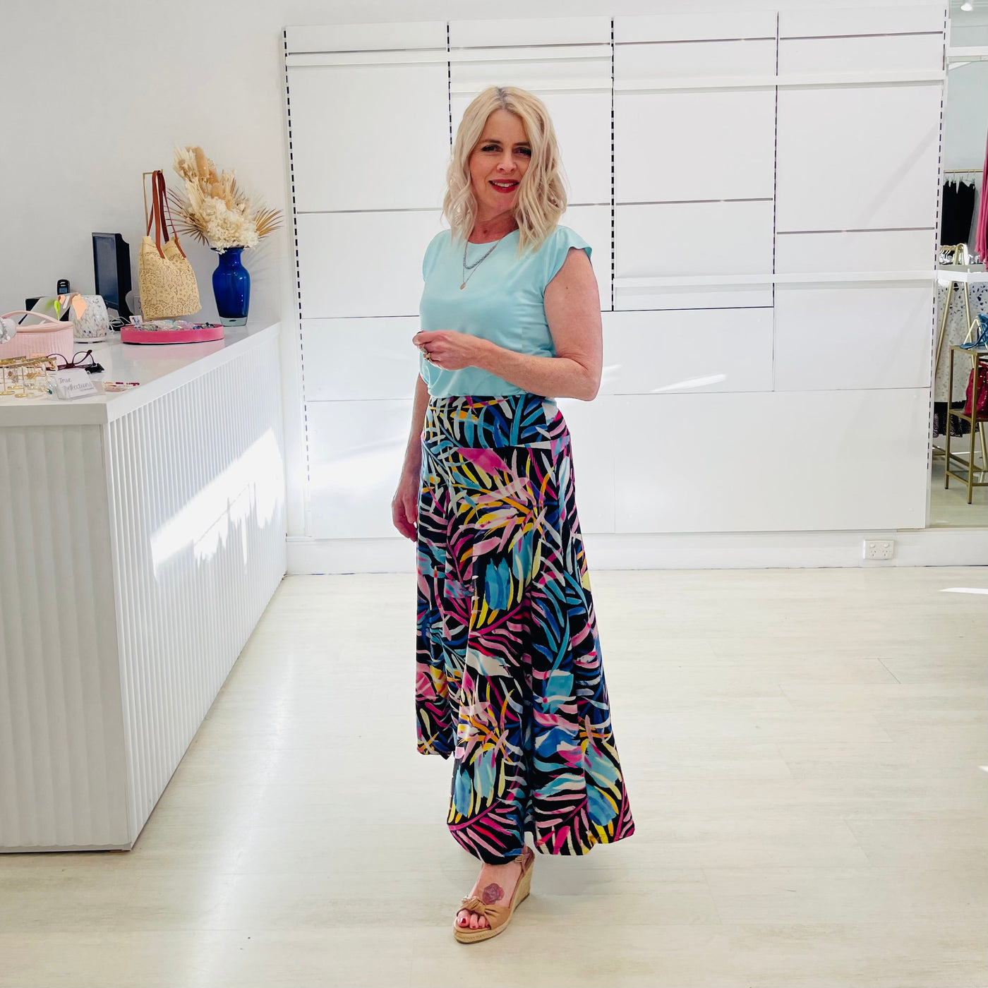 Woman wearing blue t shirt with long floral skirt. 