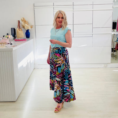 Woman wearing blue t shirt with long floral skirt. 
