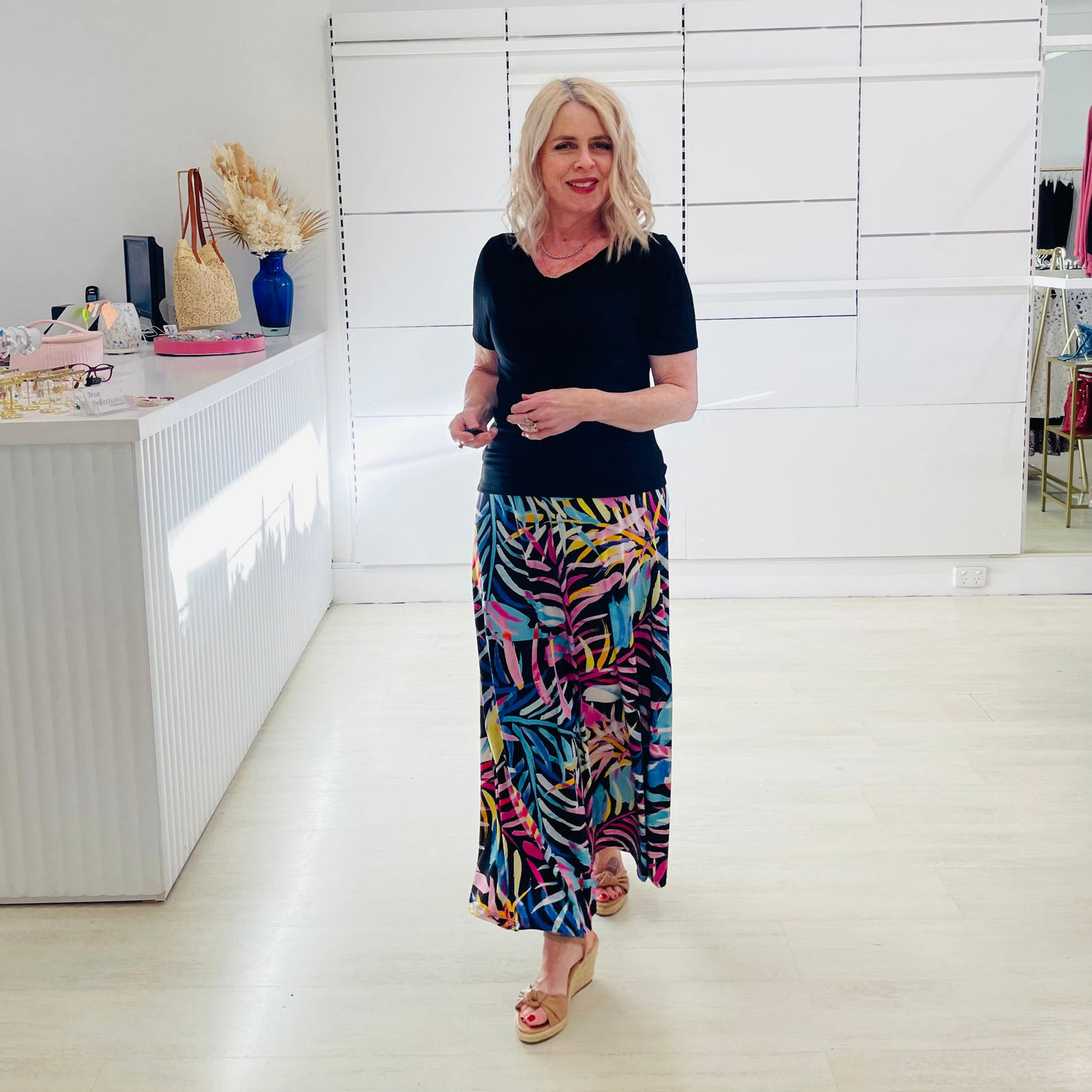 Woman wearing black dressy top with long floral maxi skirt. 