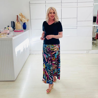 Woman wearing black dressy top with long floral maxi skirt. 