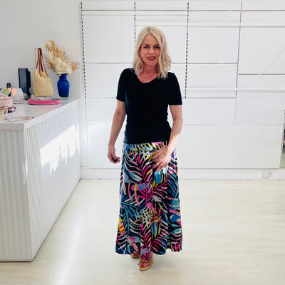 Woman wearing black dressy top with long floral skirt. 