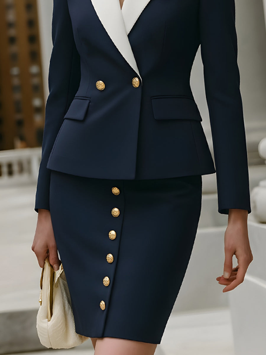 granatowym kostiumie ze spódnicą z kontrastowym kołnierzem i złotymi guzikami