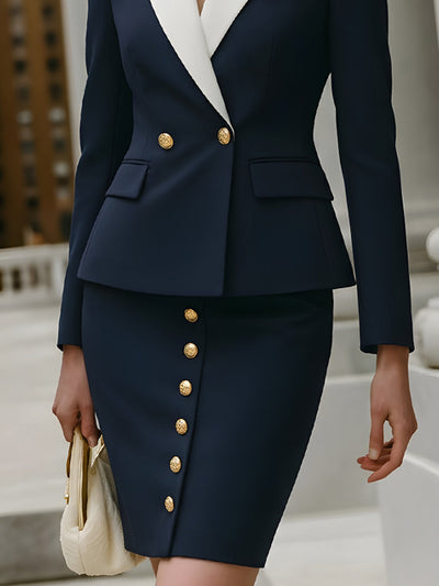 granatowym kostiumie ze spódnicą z kontrastowym kołnierzem i złotymi guzikami