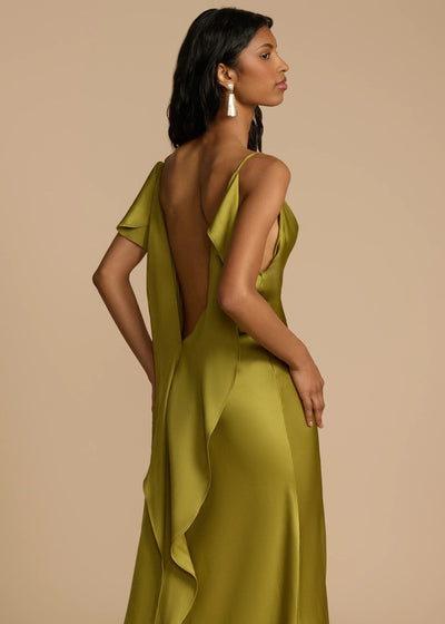 Woman wearing a green dress with a backless design on a beige background