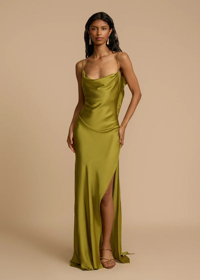 Woman wearing a green satin gown against a beige background